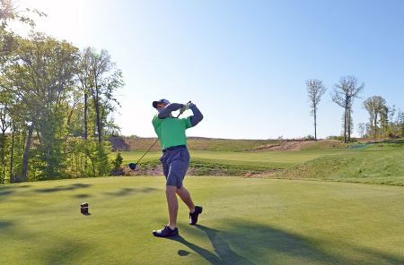 Army veteran Nick McCormick takes the first swing at the grand opening of the Potomac Shores Golf Club in Prince William County, Va., on Monday, May 5, 2014. 
